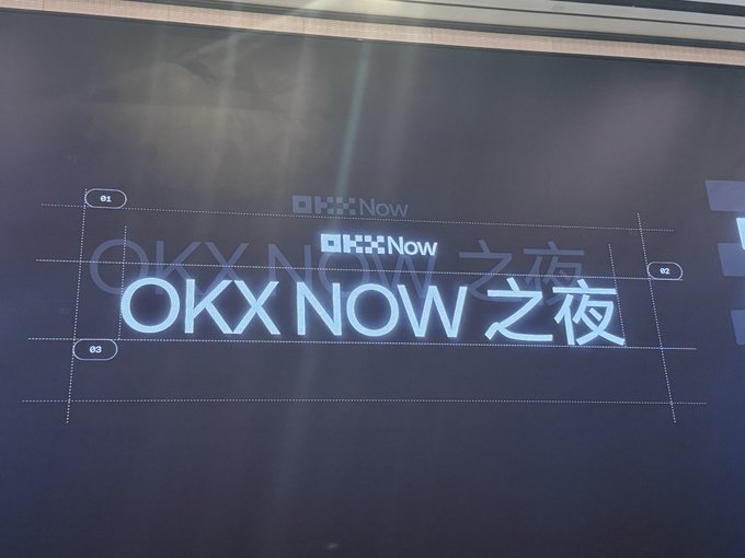 A sign or display featuring the text "OKX NOW 之夜" (OKX NOW Night) in white lettering on a dark background