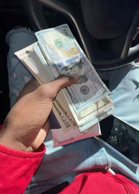 A hand holds a large wad of US hundred dollar bills, fitting the post's promise of making money. Visible text includes "100" on the bills and "TRUIST" on a folded paper.