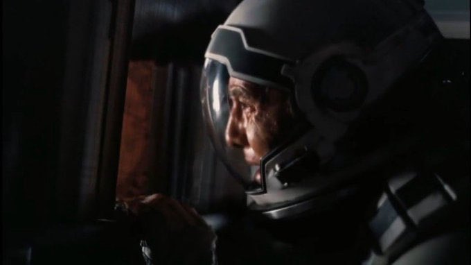 An astronaut in a space helmet stares intensely out of a cockpit window, his face illuminated by dim light in a moment of frustrated concentration. The image humorously mirrors the feeling of obsessively watching the market for a perfect entry point, only to miss the opportunity entirely.