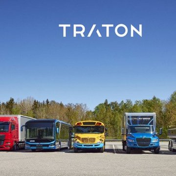 The image displays the TRATON logo prominently against a blue sky, with four commercial vehicles from the company's brands (including MAN, Scania, and Navistar) lined up below. This visual relates to the news of TRATON, Volkswagen's commercial vehicle giant, selecting Ripple Treasury to manage its treasury operations, representing the diverse fleet of brands under the TRATON umbrella now leveraging Ripple's financial platform.