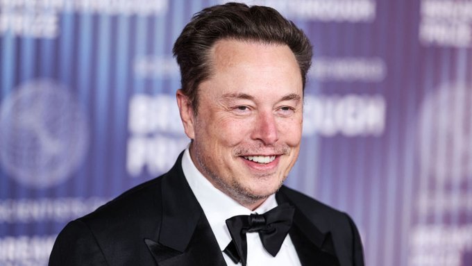 The image features a man dressed in a tuxedo with a bow tie, smiling at the camera. The background of the photo shows a blue wall with white text that reads "HOLY COW: Anyone who bought SpaceX's IPO 4 days ago, is now outperforming every single person who held Ethereum for the last 5 years." This statement suggests that the man in the image might be referring to someone named Tesla or another individual who invested in the SpaceX company and has been outperforming those who invested in Bitcoin.