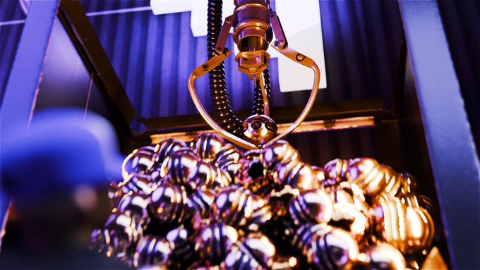 A robotic claw hovers above a pile of shiny metallic spheres, reflecting copper and blue hues, symbolizing the smooth, high-speed handling of digital assets on the Solana blockchain.