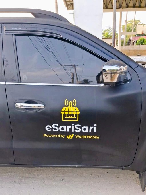 A close-up of a black vehicle door displaying the 'eSariSari' logo and 'Powered by World Mobile' text.