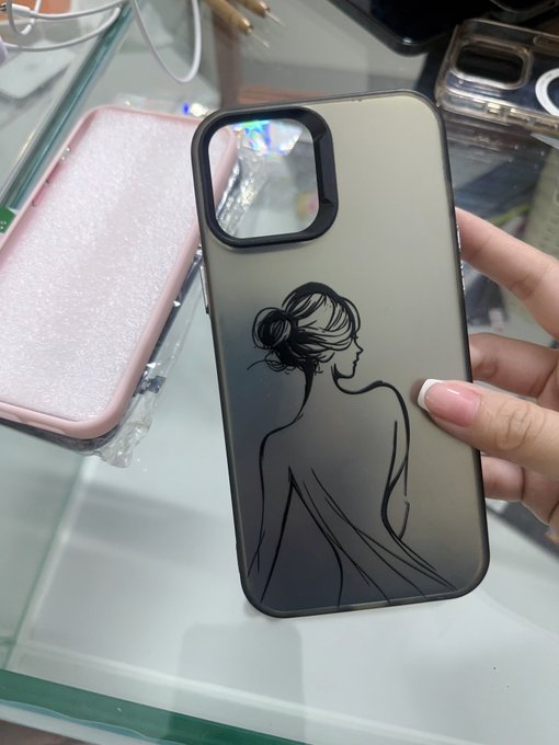 A hand holds a frosted black phone case featuring a minimalist line drawing of a woman with a hair bun and a bare back, displayed over a glass surface.
