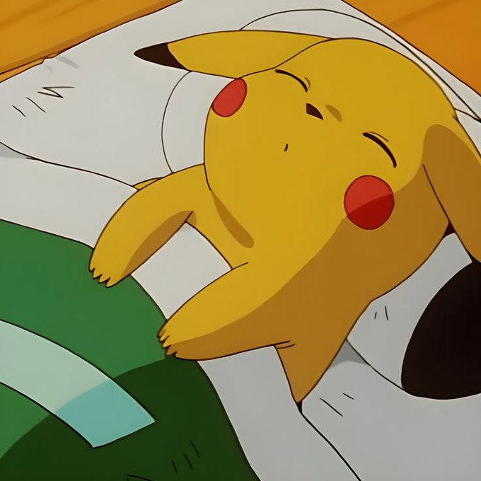 An animated scene of Pikachu sleeping peacefully on a white pillow, with eyes closed and a content expression, in what appears to be from the Pokémon anime series.