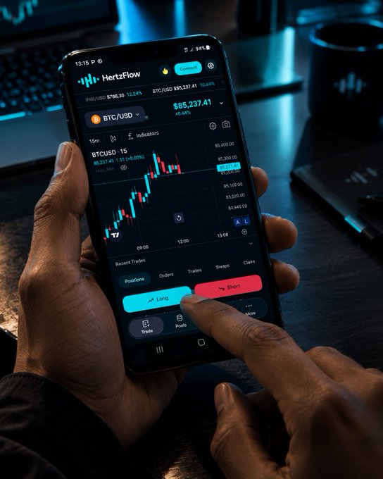 A person holds a smartphone displaying the 'HertzFlow' trading app with a BTC/USD chart priced at $85,237.41, as their finger hovers over a red 'Short' button.