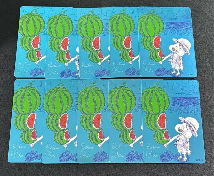 The image shows ten identical trading cards arranged in two rows of five, each featuring a cartoon girl carrying a stack of watermelons with the text "Cuchina Oda" and "©2015" visible in the corners. The post's claim about securing Metakira NatsuComi Luffy cards appears unrelated to the image, as these cards do not depict Luffy, contain any NFT or crypto imagery, and instead show what looks like a Cucumber/ODA-themed collectible card from 2015.