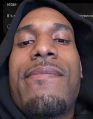 A close-up shows a man with a goatee wearing a dark hooded sweatshirt, appearing weary or dejected, which visually echoes the post's message about crypto trader Ansem conceding defeat on his $90,000 Bitcoin call and bracing for a potential further 20% drop.