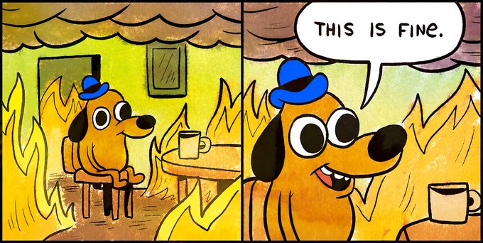 A two-panel comic shows a cartoon dog wearing a blue cap, calmly sitting at a table with a coffee mug while flames engulf the room. In the second panel, the dog proclaims "THIS IS FINE." in a speech bubble, smiling through the surrounding fire.

The image is the popular "This Is Fine" meme, used to humorously depict traders staying loyal to BTC and the S&P 500 even as Pokémon cards dramatically outperform them in 2026.