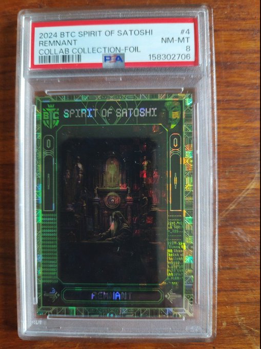 A PSA-graded trading card encased in a protective slab, labeled '2024 BTC SPIRIT OF SATOSHI REMNANT' and 'COLLAB COLLECTION-FOIL' with a grade of NM-MT 8.
