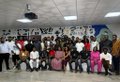 A low-resolution group photo of people posing together indoors, likely a company team or event gathering.