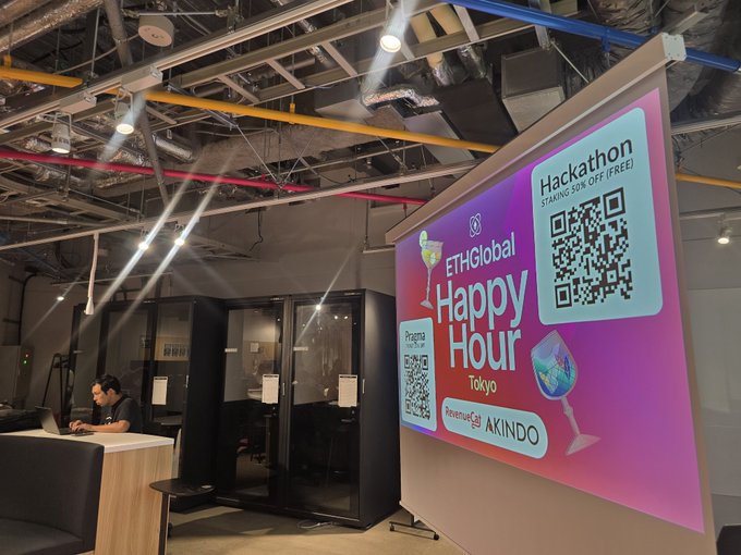 A projection screen at an ETHGlobal Happy Hour event in Tokyo displays a promotional advertisement for a Hackathon offering a 30% discount, featuring QR codes for event sign-up and sponsorship by AKINDO.
