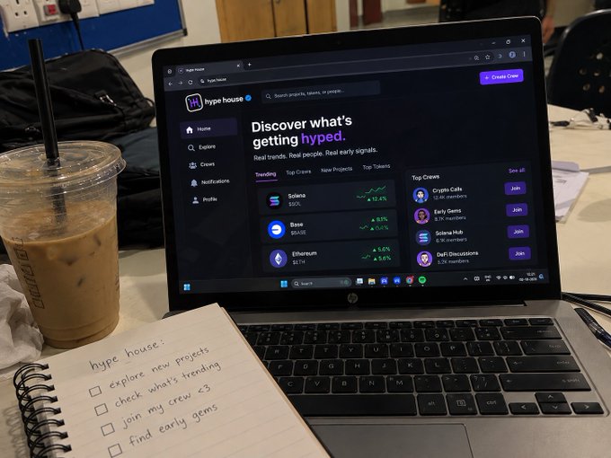 A laptop displays the 'hype.house' website with the tagline 'Discover what's getting hyped', showing trending coins like Solana, Base, and Ethereum, alongside an iced coffee and a handwritten to-do list.