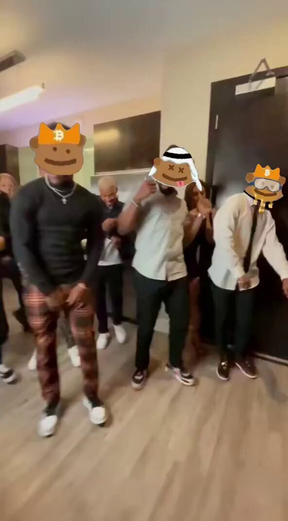 The image shows a group of people standing together, with two men wearing masks that resemble cartoon characters or animals. The other people are dressed in regular clothes. They appear to be posing for a photo, possibly at an event or gathering where they have been given free $GRIZZY PFPs (Runes) as part of the distribution process. The post mentions that phase 2 of the airdrop is approaching and that 200 new PFPs will be distributed: 50 guaranteed for the top 50 holders and 150 randomly distributed to eligible wallets.
