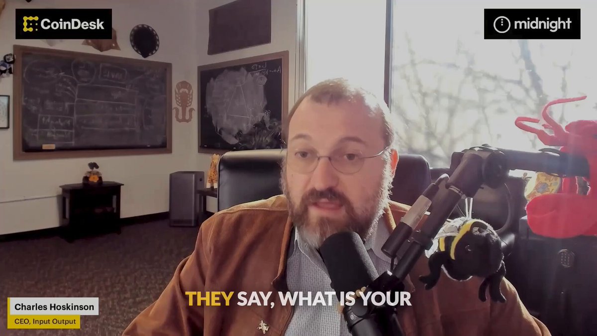 The image shows a man wearing glasses, seated at a desk with a microphone in front of him. He appears to be talking into the microphone during an interview or podcast recording session. The background features a window that allows natural light to enter the room, creating a comfortable atmosphere for the conversation. There is also a chalkboard visible on one side of the room.

The post about @Starknet mentions that someone sitting next to the man can tell him about it. This implies that there might be some information or context related to the topic being discussed in the image, possibly involving the man with glasses and the microphone.
