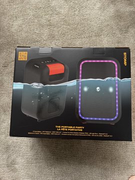 A box for a 5W portable IPX7 waterproof Bluetooth speaker with RGB lights and a subwoofer, used as the prize for a giveaway. The caption ties into the family-based giveaway story, showing the product that one lucky winner received after being chosen by Grok and then picked from five finalists by the poster's wife and kids.