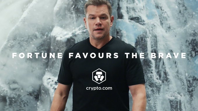 Actor Matt Damon stands in front of a glacial backdrop wearing a black Crypto.com t-shirt, with the text "FORTUNE FAVOURS THE BRAVE" overlaid across the image.