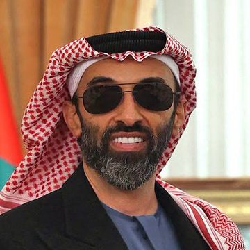 A smiling man with a beard wears sunglasses, a traditional red and white checkered keffiyeh headdress, and a dark blazer, identified as Sheikh Tahnoon bin Zayed al Nahyan, the UAE national security adviser who holds a significant stake in the Trump-backed crypto venture World Liberty.