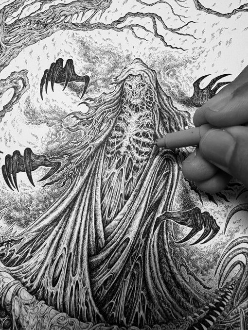 A black-and-white ink drawing shows a hand using a fine-tipped pen to illustrate a sinister hooded figure with a spidery mask, webbed patterns on its chest, and clawed hands reaching outward.