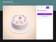 A small, blurry screenshot of a cake decorating webpage titled 'Decorate cake' showing a white cake with pink decorations.
