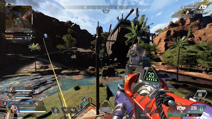 A first-person view from the video game Apex Legends, showing a player aiming a red weapon in a desert canyon environment.