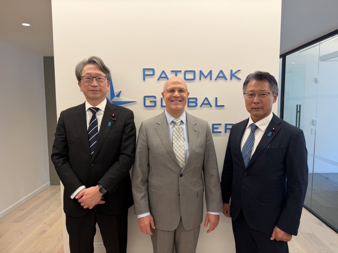 Three men in business suits pose together at the Patomak Global Partners office, with the company name and logo visible on the wall behind them. The image relates to the post's mention of "BCCC" (likely a meeting or organization), suggesting this photo was taken during a business meeting or conference related to financial regulations, potentially connecting to discussions about DeFi policy in Japan.