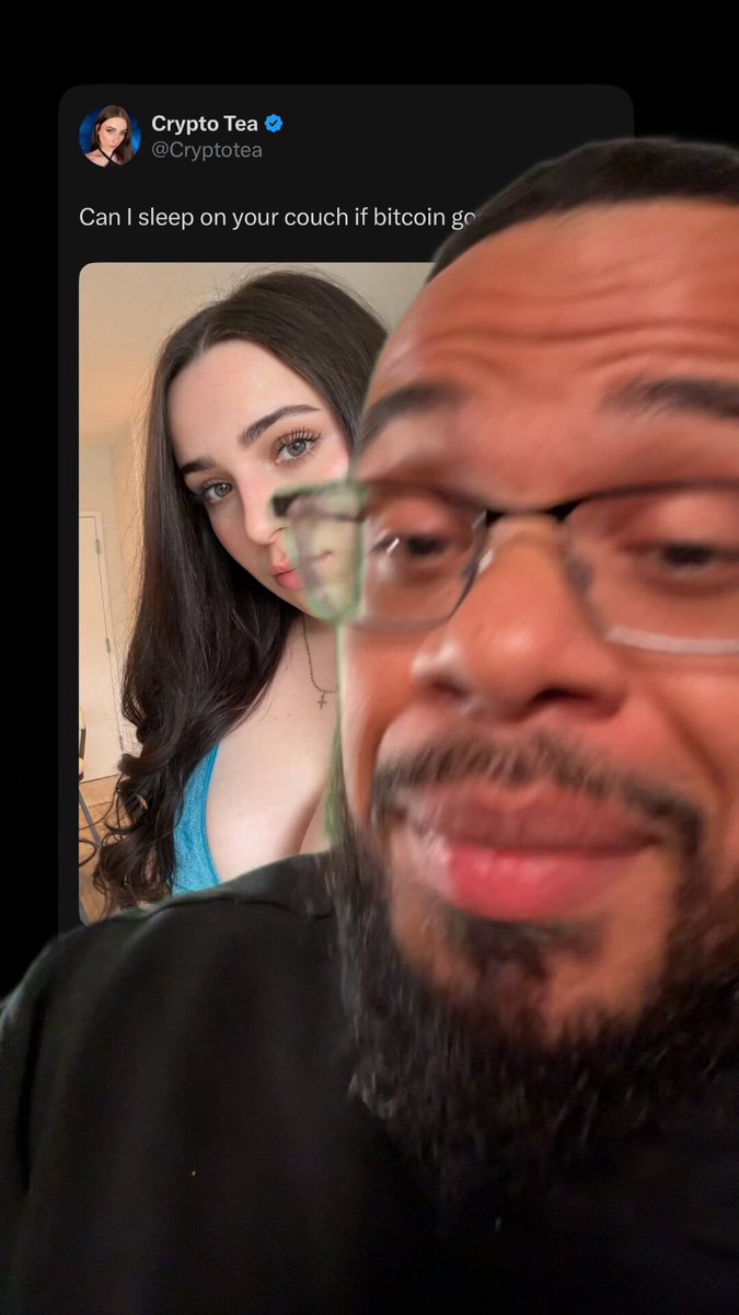 The image shows a man wearing glasses, a black shirt, and a beard with his face partially visible behind another woman who has her hair styled in an updo. The man appears to be looking at the camera while the woman is taking a selfie of him. The caption on the image reads "Can I sleep on your couch until Bitcoin? Can you do that?" This suggests that the man might be interested in the woman's Bitcoin investment and wants to know if she can invest with him or not.