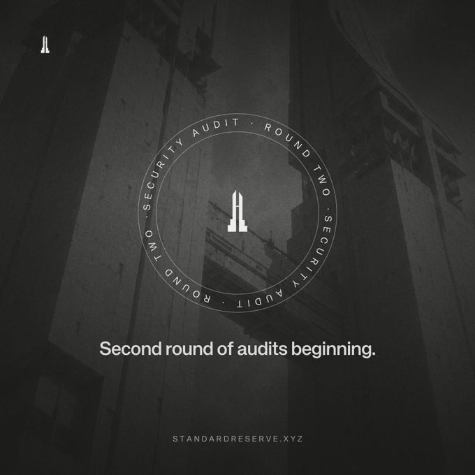 A dark, minimalist graphic with the text 'Second round of audits beginning.' and 'STANDARDRESERVE.XYZ' at the bottom, featuring a circular 'SECURITY AUDIT · ROUND TWO' seal over a shadowy industrial background.