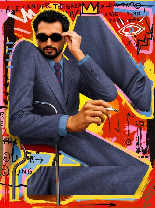 Vibrant pop-art style portrait of a man in a gray suit and sunglasses holding a cigarette, set against a colorful background with graffiti-like text reading 'ALEXANDER THE GREAT' and 'JEAN-MICHEL BASQUIAT' style markings.