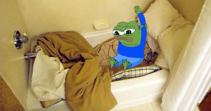 A photo of a bathroom with a white bathtub filled with brown blankets and pillows, featuring a digitally-added cartoon Pepe the Frog character sitting inside.