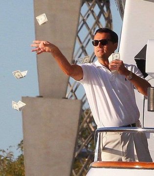 Leonardo DiCaprio's iconic "money from the air" scene from *The Wolf of Wall Street* is used as a metaphor for the Flaznorp Polymarket trader's algorithmic trading, which generated $1,257,280 in profit by executing 47,645 predictions in 20 days—depicting money appearing effortlessly through automated execution.