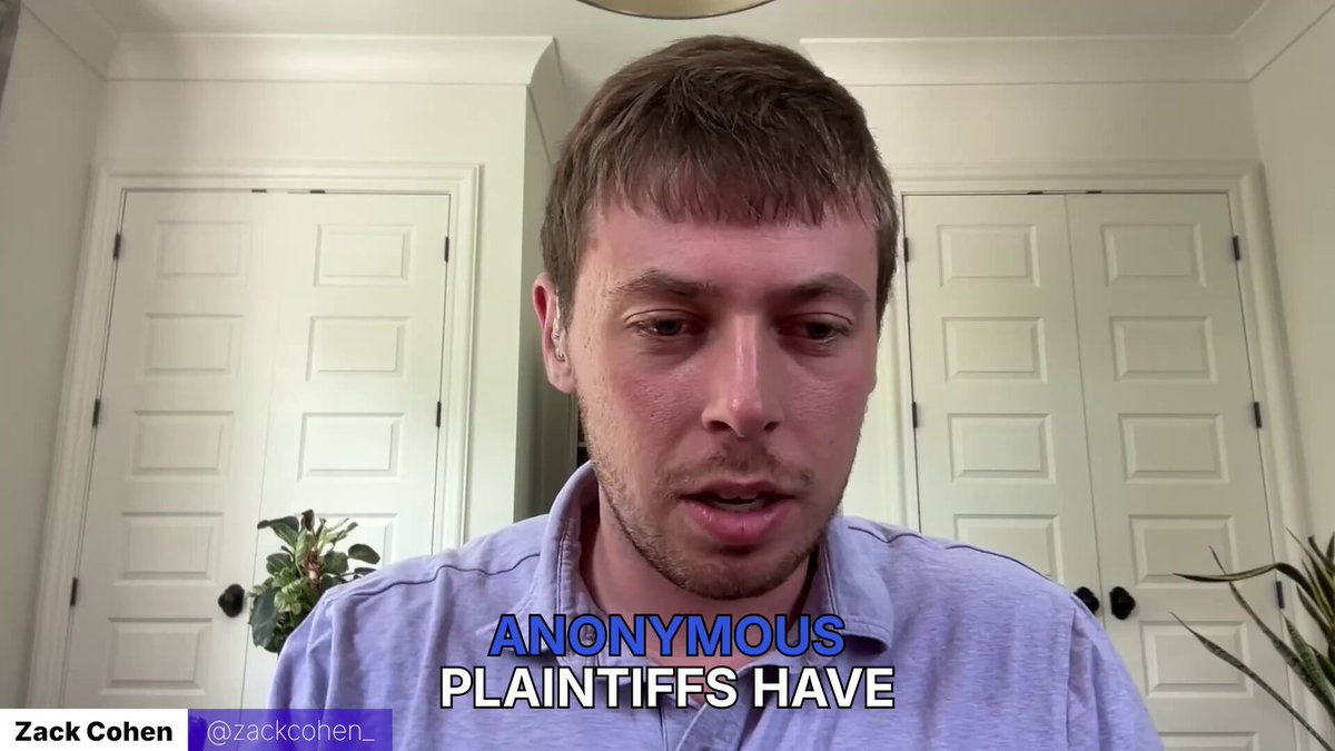 The image shows a man wearing a purple shirt with the words "Anonymously Plaintiffs Have" written above his head. The man appears to be talking about a recent court case involving Bitcoin. The text suggests that there might have been an abandoned Bitcoin property, and the man is asking for it to be returned as lost Bitcoins tied to Satoshi.