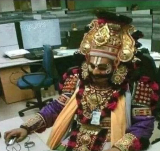 A person in elaborate, gold-ornate ceremonial regalia sits at an office desk handling tech support equipment, humorously labeled as "Coinkite Level 3 Tech Support"—the absurd contrast suggesting this deity-like figure is reserved for the most complex, escalated issues.