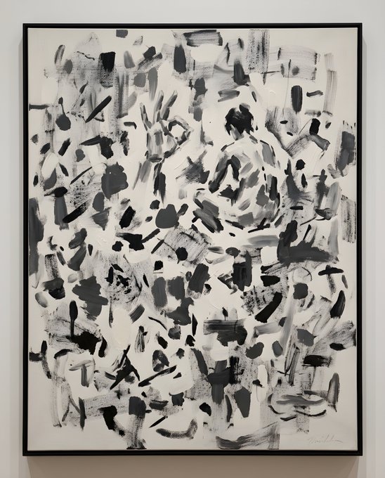An abstract black-and-white painting in a black frame featuring expressive gestural brushstrokes and a signature in the lower right corner.