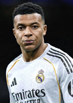 The photo shows footballer Kylian Mbappé wearing a white Real Madrid jersey featuring the club crest and the "Emirates" sponsor logo, with his eyes closed. The image relates to the breaking news of his departure from Nike, likely highlighting his transition away from the Nike apparel line he previously endorsed.