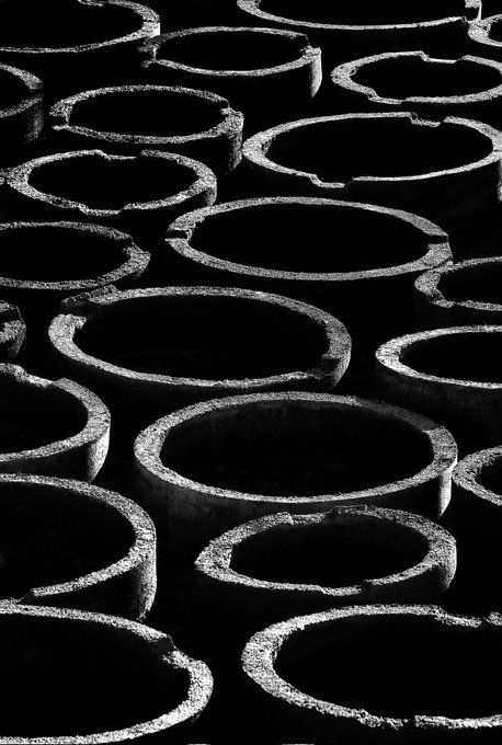 The image features a group of small circular objects or shapes that are identical to each other, which appear to be made out of concrete. The shapes are grouped together against a black background, creating an interesting visual effect due to their uniformity. There's also some text in the image, likely providing information about the object or its source. The post is from "Bright circles" and it talks about photography focusing on what is in the image.
