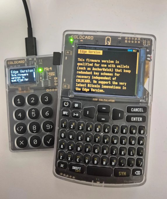 A transparent COLDCARD Mk4 Bitcoin hardware wallet connected via USB to a calculator device (Edge Version firmware), both displaying screens with text about firmware versions qualified for use with wallets.