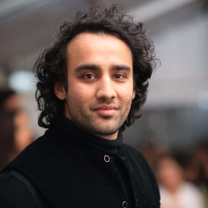 A man with curly dark hair and a slight smile, wearing a black coat, looks off-camera. The portrait appears to accompany a post about Bilal Bin Saqib, Chair of Pakistan's Virtual Assets Regulatory Authority, advocating for rapid policy development to keep up with technological advancement.