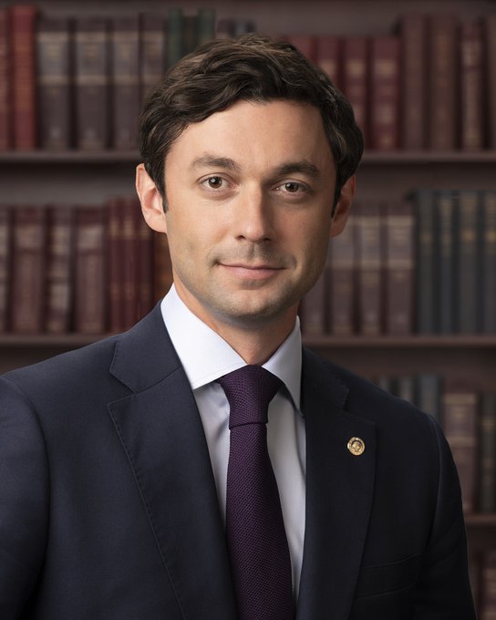 A formally posed portrait shows a man in a dark navy suit with a burgundy tie and a gold lapel pin, standing before shelves of leather-bound books. The image appears to depict Jon Ossoff, the politician highlighted in the accompanying post as the current frontrunner for the 2028 Democratic presidential nomination.