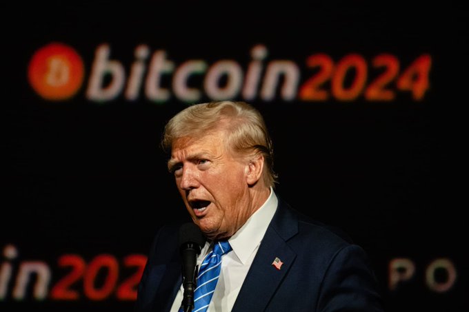 Donald Trump speaks in front of a "Bitcoin 2024" backdrop, relating to claims that he and his circle have extracted $635,000,000 from cryptocurrency, including the WLFI token.