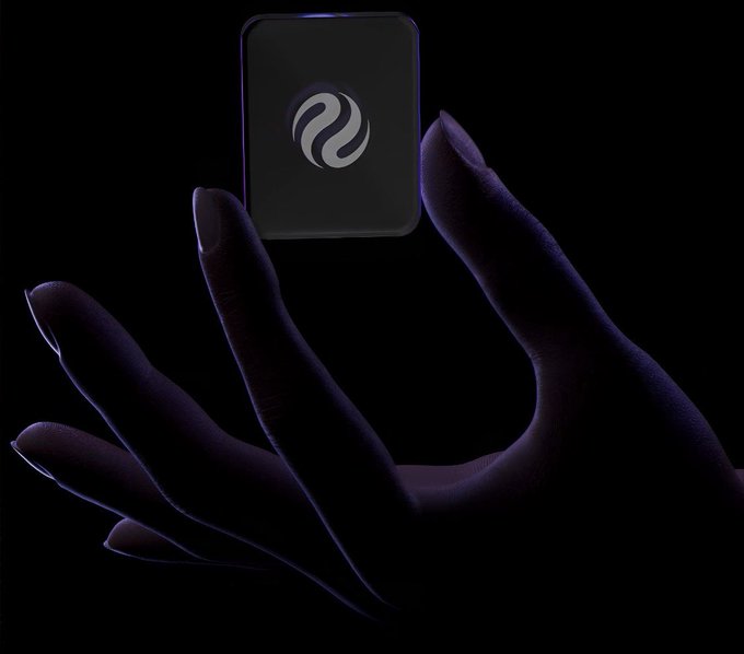A dark, moody image showing a silhouetted hand holding up a glowing square device featuring a curved wave-like logo against a black background.