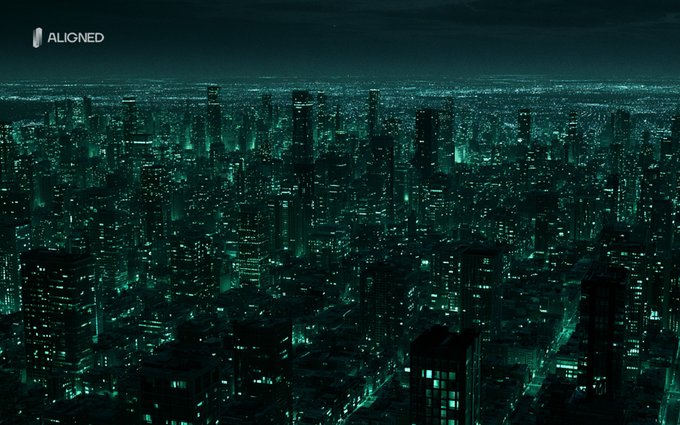 An aerial view of a sprawling city skyline at night, tinted with a green color grade, with numerous illuminated skyscrapers and street lights extending into the distance, and a logo for 'ALIGNED' in the upper left corner.