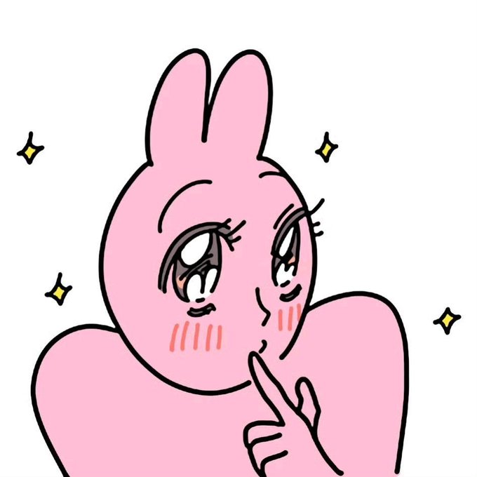 A pink cartoon-style illustration of a rabbit-like character with large expressive eyes, blushing cheeks, and a finger pressed to its lips in a 'shushing' gesture, surrounded by small sparkle decorations.