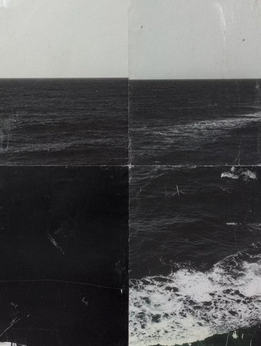 A black-and-white photograph of a dark ocean with white-capped waves crashing, showing a visible vertical seam down the middle.