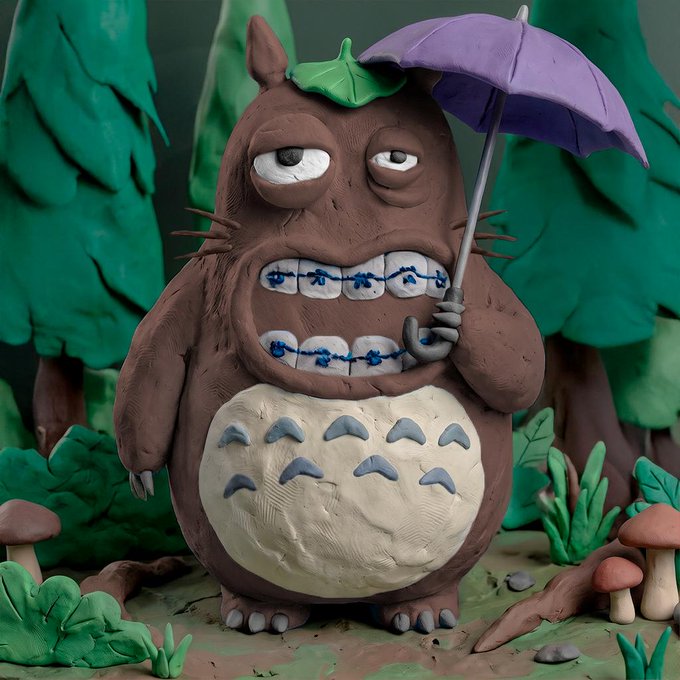 A clay figure of Totoro (referred to as "t00ntoro") stands in a forest scene with green trees and mushrooms, holding a purple umbrella and wearing a green leaf on its head, complete with its signature braces and gray belly markings. This stop-motion style sculpture represents the 1-of-1 unique NFT collectible mentioned in the post.