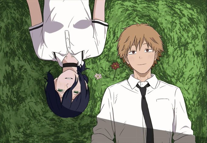 An anime scene featuring a young man with brown hair lying on grass next to a dark-haired character who is positioned inversely.