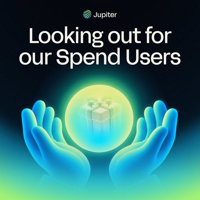 The image is a promotional graphic from Jupiter featuring the text "Looking out for our Spend Users" above an illustration of two blue glowing hands cradling a green-lit gift box, symbolizing care and reward protection. It visually reinforces the post's message about Jupiter reviewing their cashback and referral rewards to ensure promises are kept for spend users.
