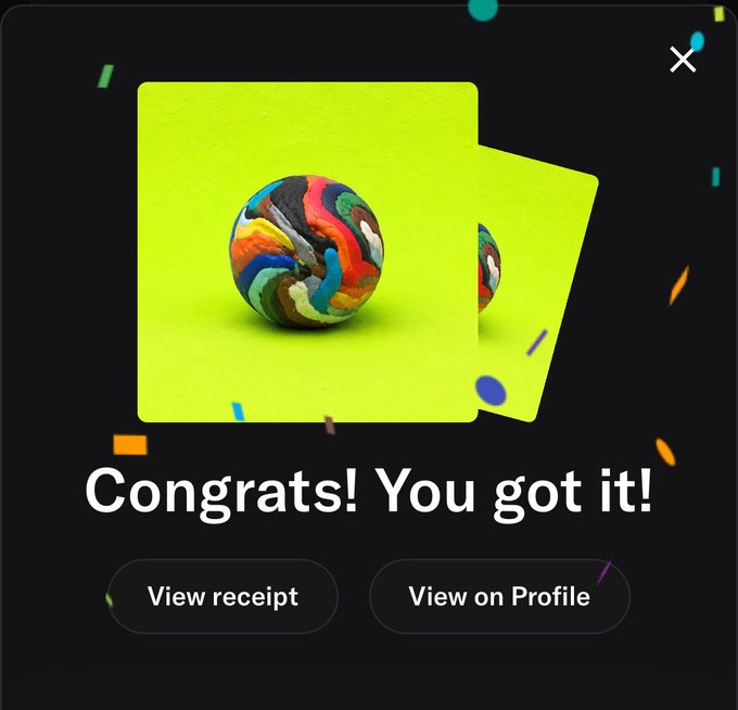 A digital achievement screen showing 'Congrats! You got it!' with an image of a multicolored swirled donut/sphere on a green background, with buttons to 'View receipt' and 'View on Profile'.