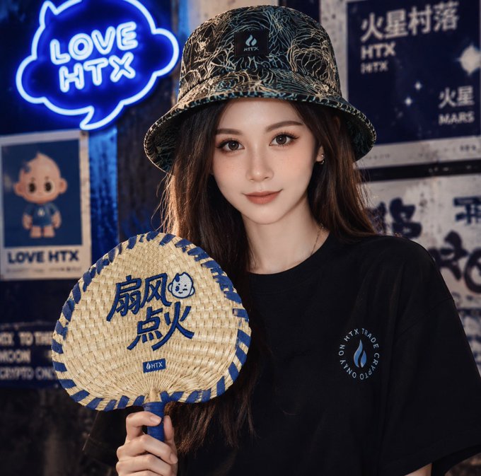 The image features a young woman wearing a hat, holding up an object that has Chinese writing on it. The woman appears to be posing for a photo or possibly giving a speech at an event. The background of the image includes various posters with different designs and colors, which adds visual interest to the scene. The presence of these posters suggests that this could be taking place in a cultural or artistic setting where people gather to appreciate art, culture, or engage in discussions about specific topics.