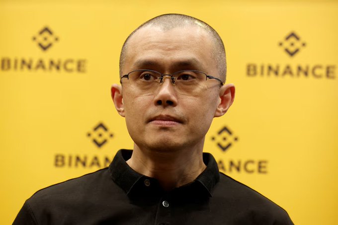 A man wearing glasses and a black collared shirt stands in front of a yellow backdrop featuring repeated "BINANCE" logos and the company's diamond-shaped symbol. The image likely depicts Jeff Li, VP of Product at Binance, as referenced in the accompanying post about the launch of Binance Agent OS.